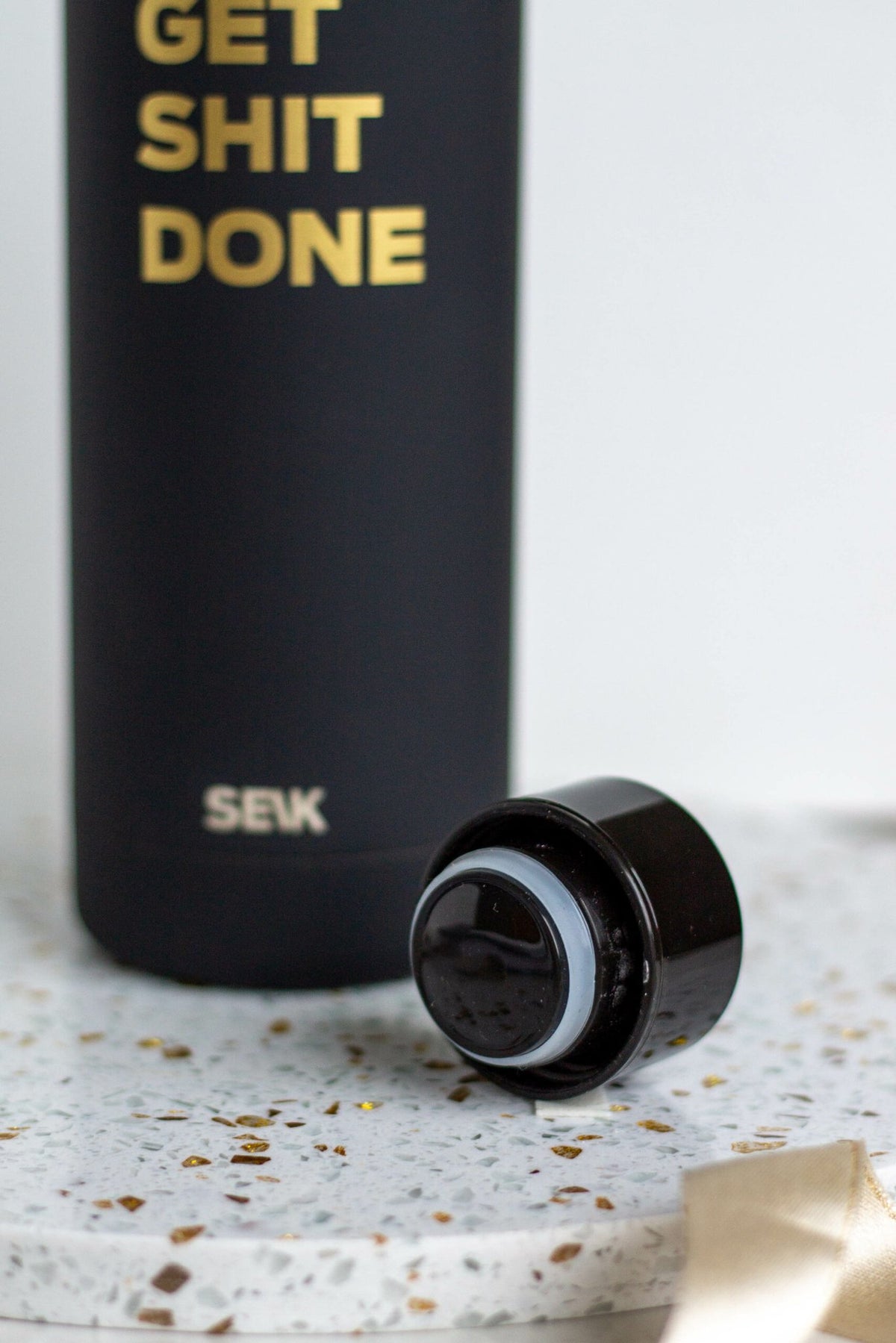3. Close-up of SEIK black water bottle cap and 'Get Shit Done' text, highlighting vacuum-insulated design
