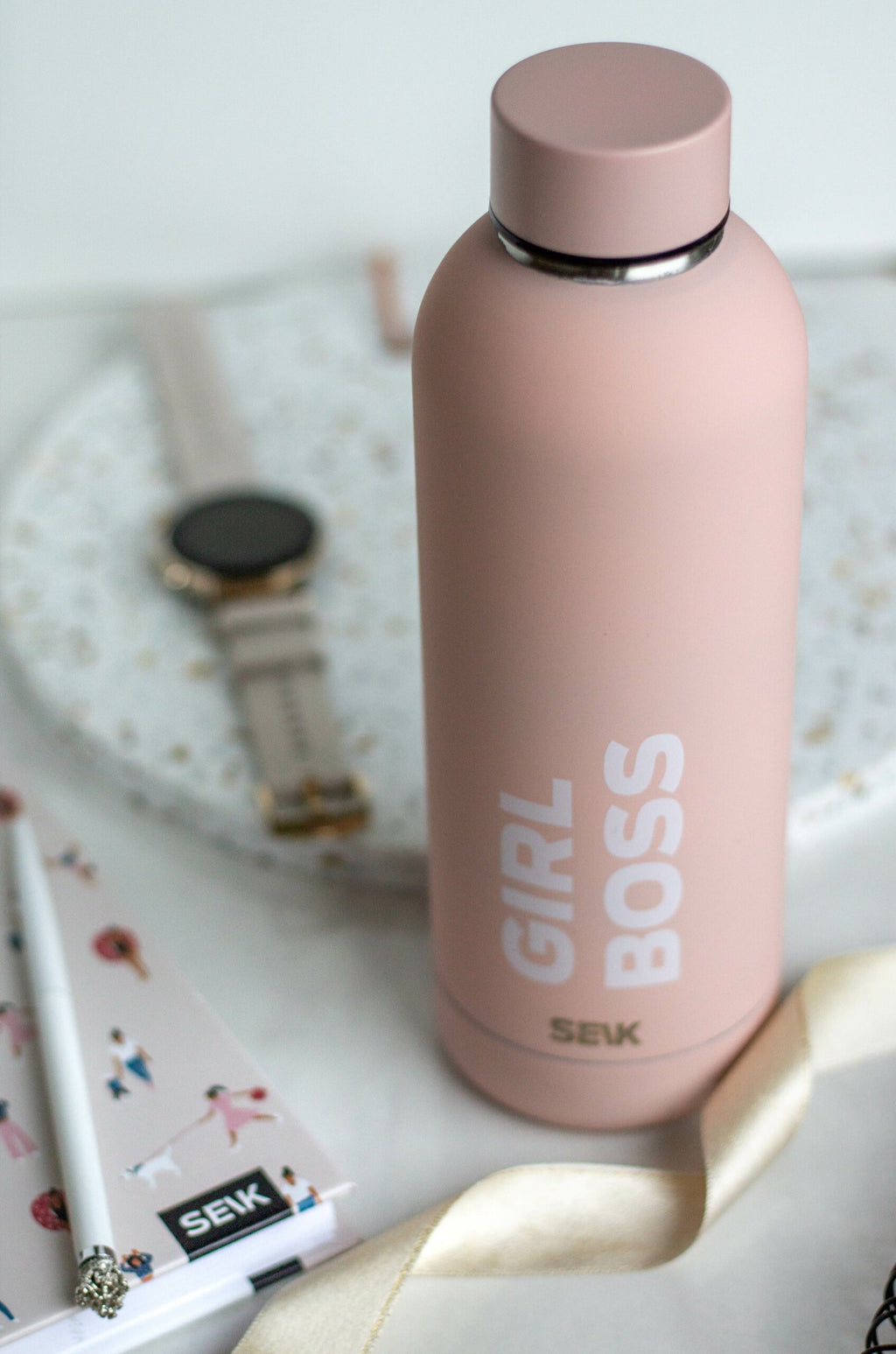 3. SEIK Girl Boss thermos in pink, displayed with a watch and notebook for a chic look