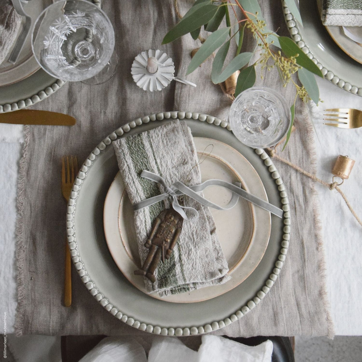 4. Rustic table setting with green striped linen napkin, vintage keys, and greenery on ceramic plates