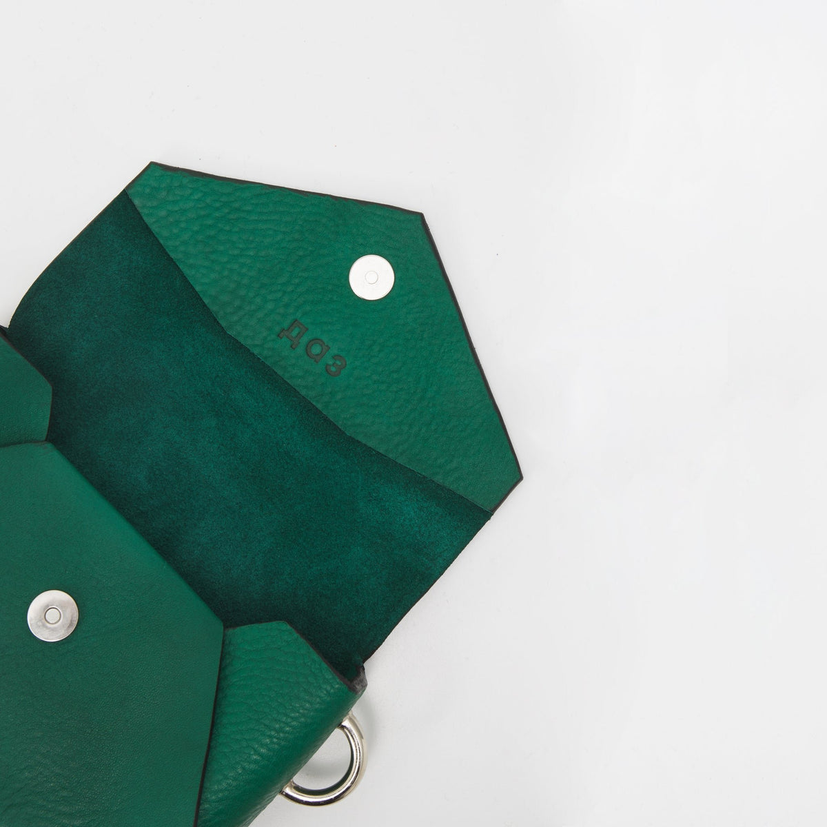 8. Open view of Daz Studio green leather envelope bag showing embossed logo and magnet closure