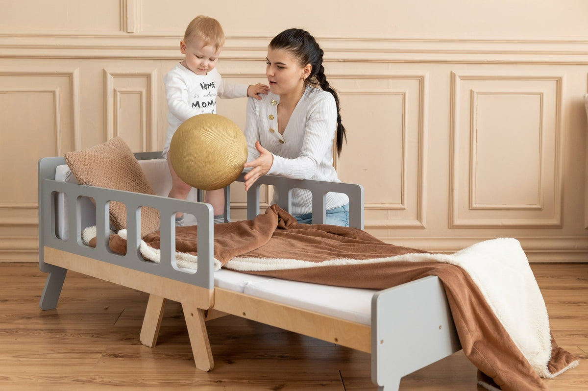 17. Woman and child playing on grey growing bed with brown blanket in elegant room