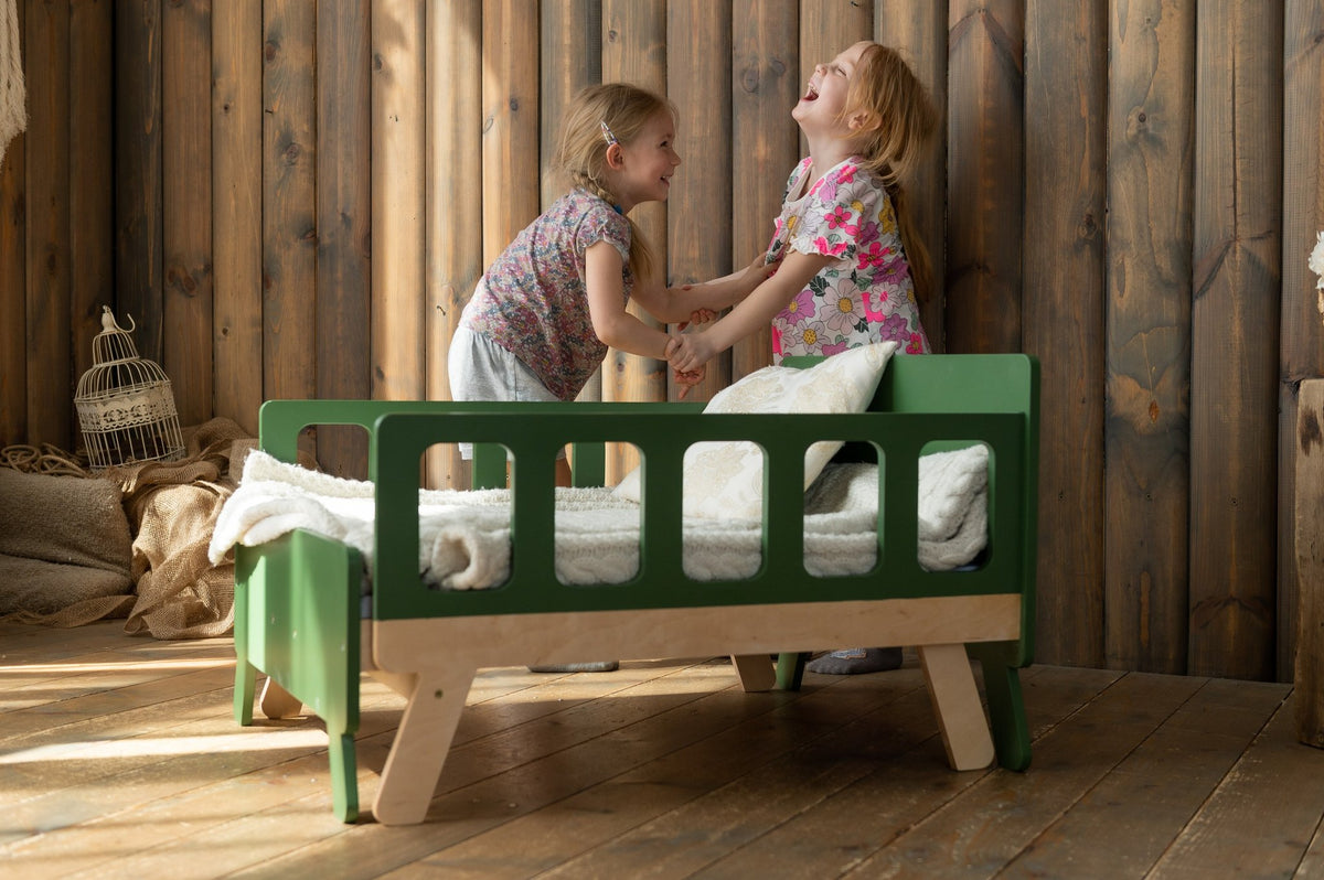 5. Two children laughing on green growing bed in wooden room with natural light