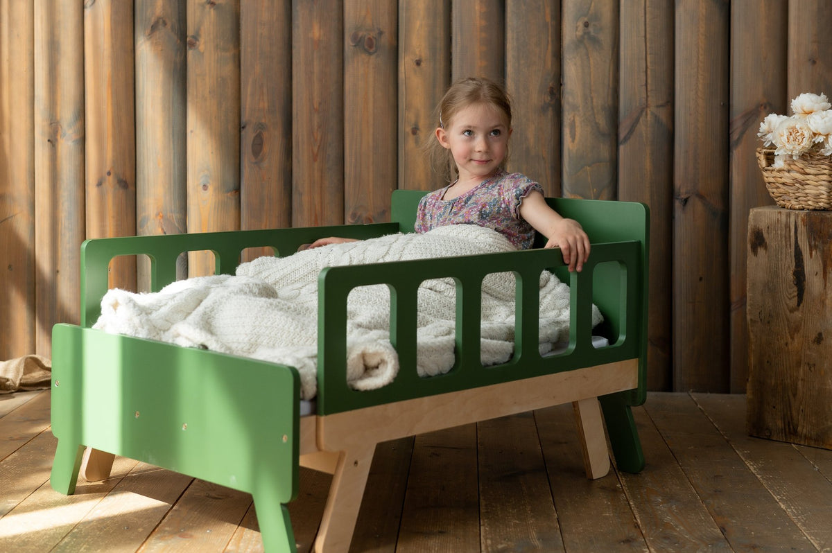 6. Child sitting on green growing bed with white bedding in wooden room