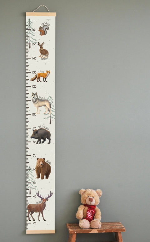 1. Children's growth chart featuring illustrated wild animals like squirrel, rabbit, and bear with English names, hanging on a wall with a teddy bear on a stool nearby, ideal for playful home decor.
