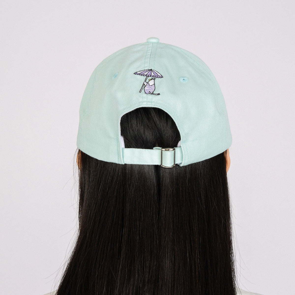 5. Back view of mint Snorkmaiden Dad Cap worn by model, showing adjustable strap