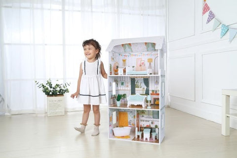 1. Young girl in white dress standing next to Gerardo's Toys wooden dollhouse Luna with LED lights in a bright room