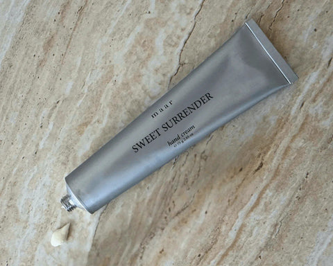 2. Silver tube of maar Sweet Surrender hand cream on marble surface with cream dollop