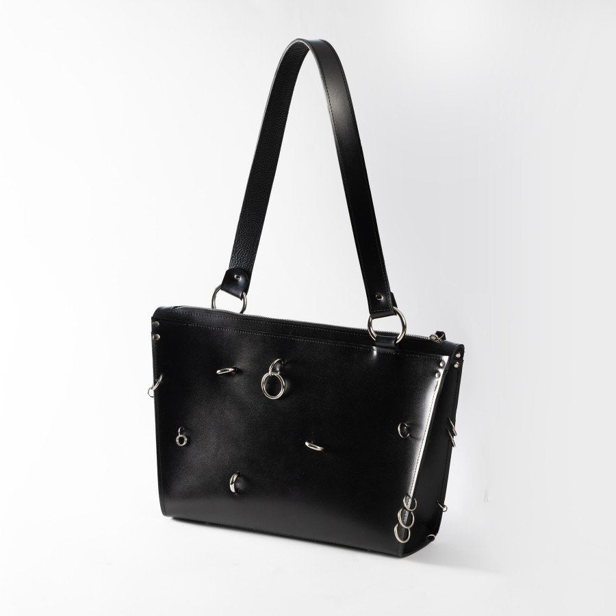 2. Black ARINA handbag with silver rings and long shoulder strap on white background