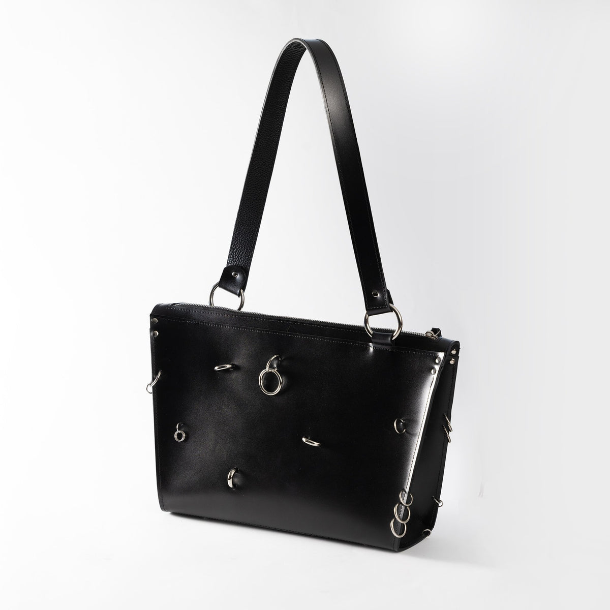 2. Black ARINA handbag with silver rings and long shoulder strap on white background