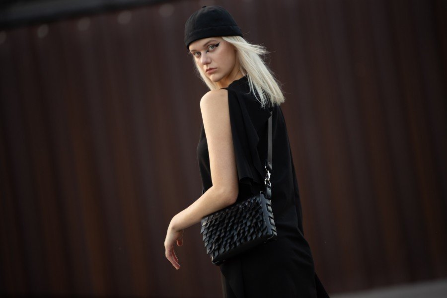 1. Woman in black outfit wearing PYKOK BARBED SISTER handbag with leather strap outdoors
