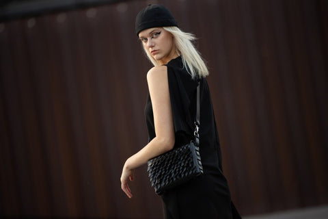 1. Woman in black outfit wearing PYKOK BARBED SISTER handbag with leather strap outdoors