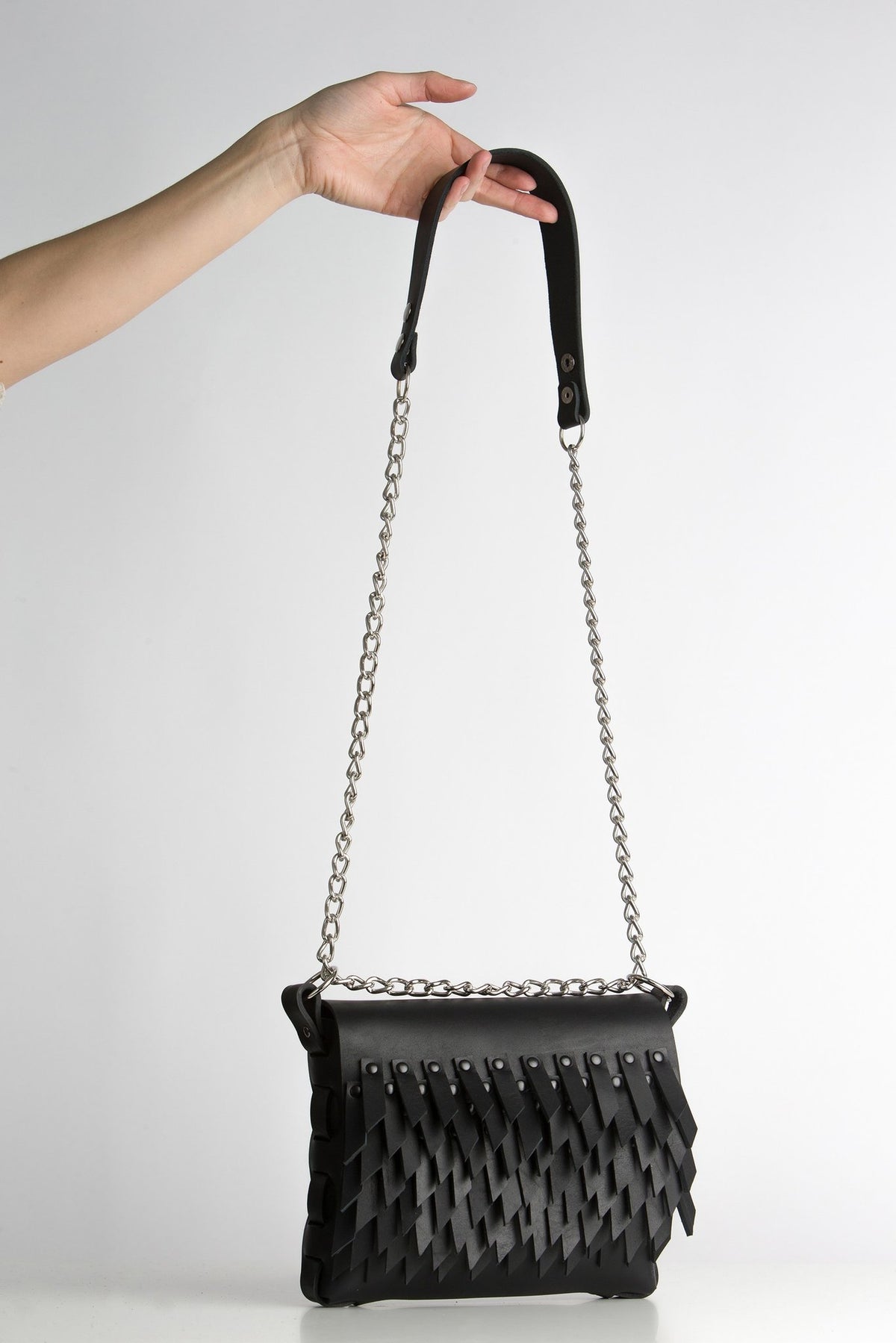 4. PYKOK BARBED SISTER handbag with chain strap held by hand against white background