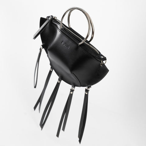 3. Black leather KAYA handbag with metal ring handles and tassels, shown at an angle against a white background