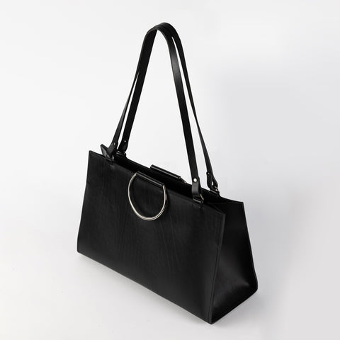 1. Black structured leather handbag with metal ring handles and long shoulder straps, shown in studio setting