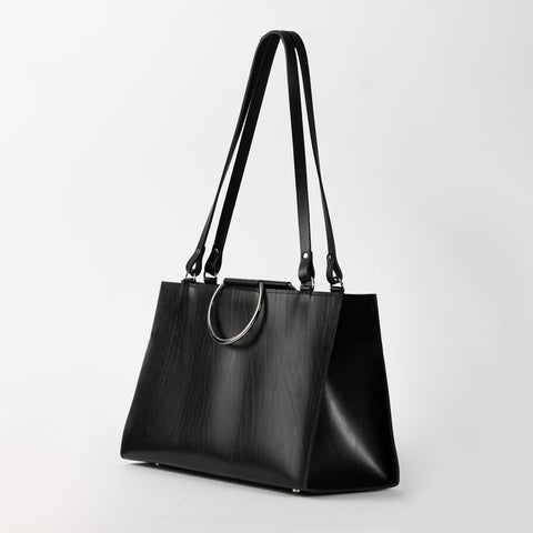 5. Black leather handbag with metal ring handles and long straps, shown in studio setting