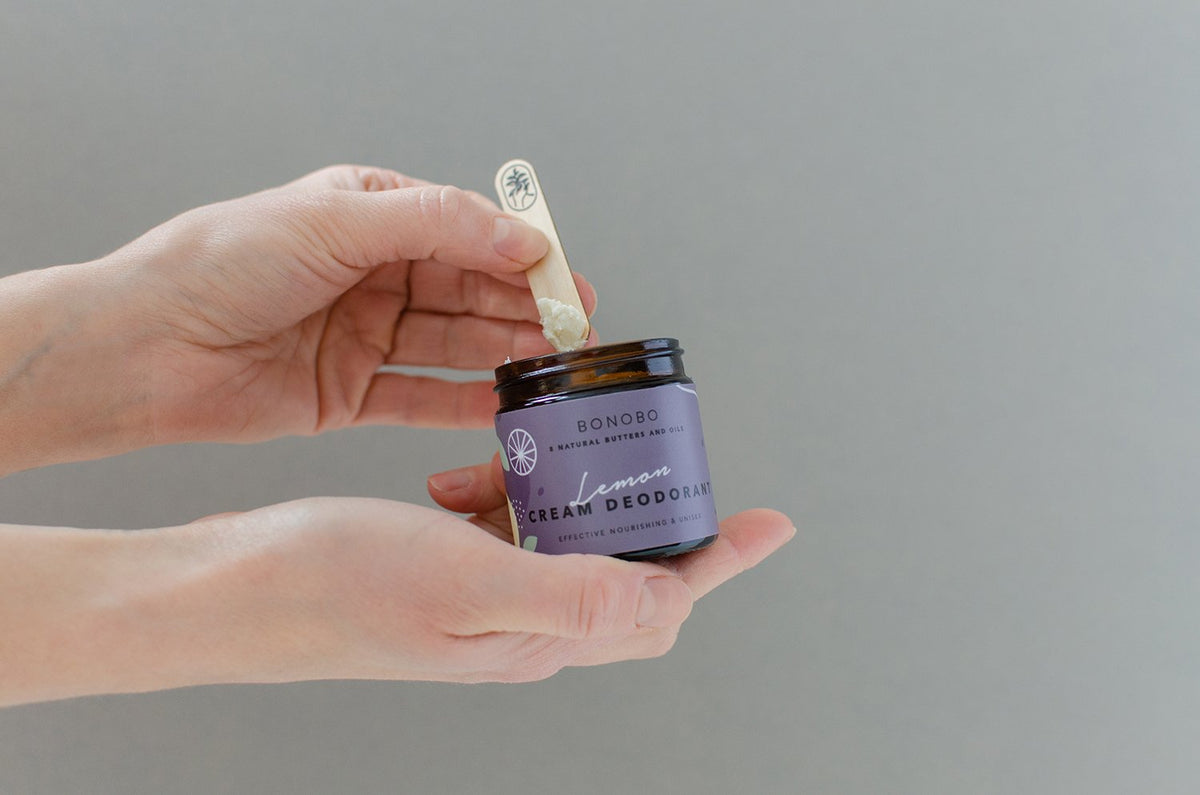 3. Hands holding BONOBO Lemon Deodorant-Cream jar with applicator in studio