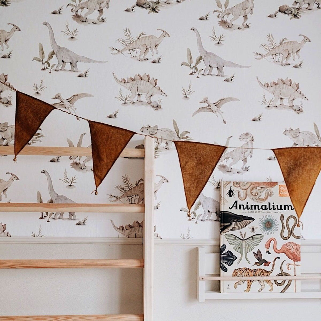 1. Children's room with dinosaur wallpaper featuring Stegosaurus, Triceratops, and Pterosaur in soft colors, wooden climbing frame, and decorative bunting