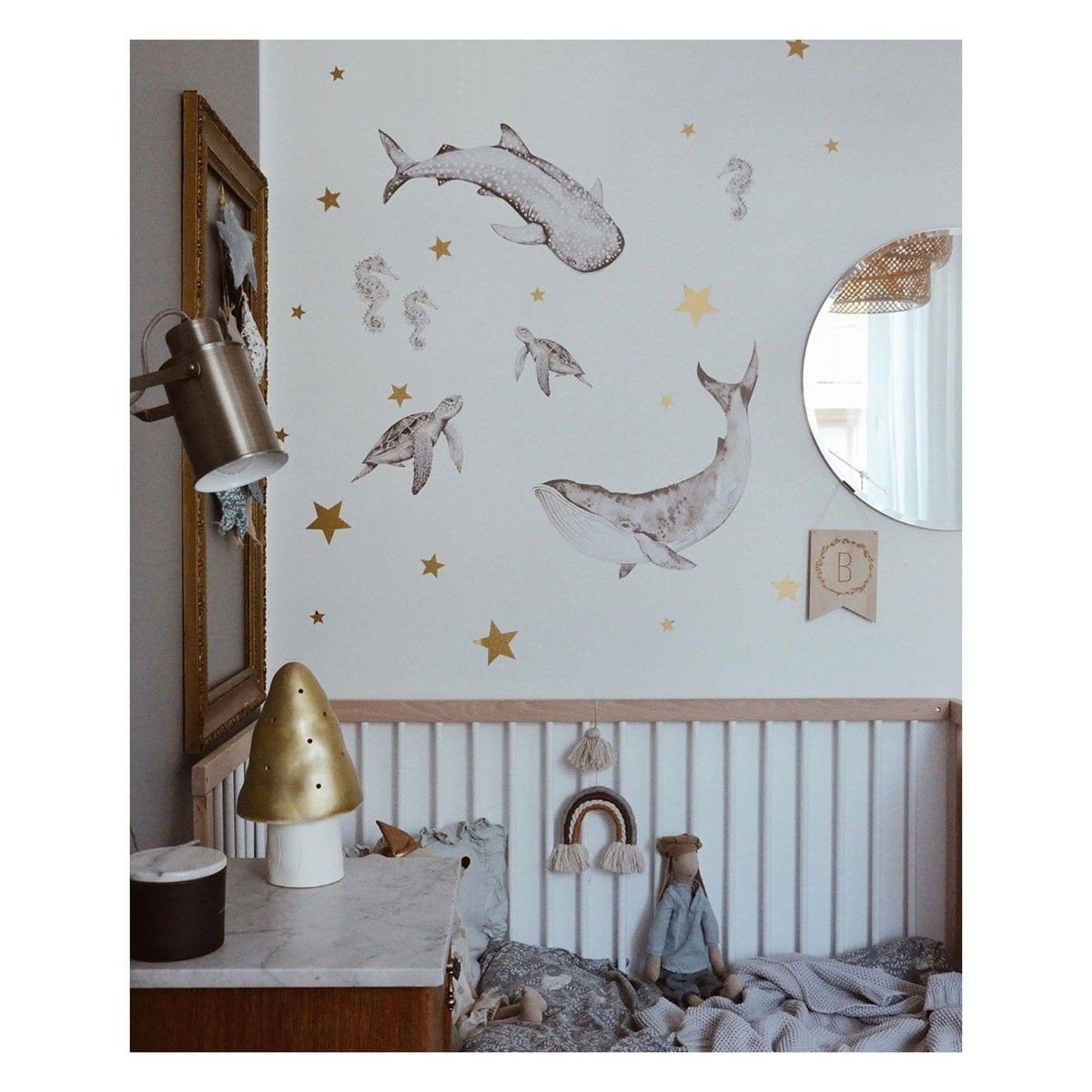 3. Close-up of nursery wall with Happy Ocean Wonderland stickers of ocean animals and gold stars above a crib