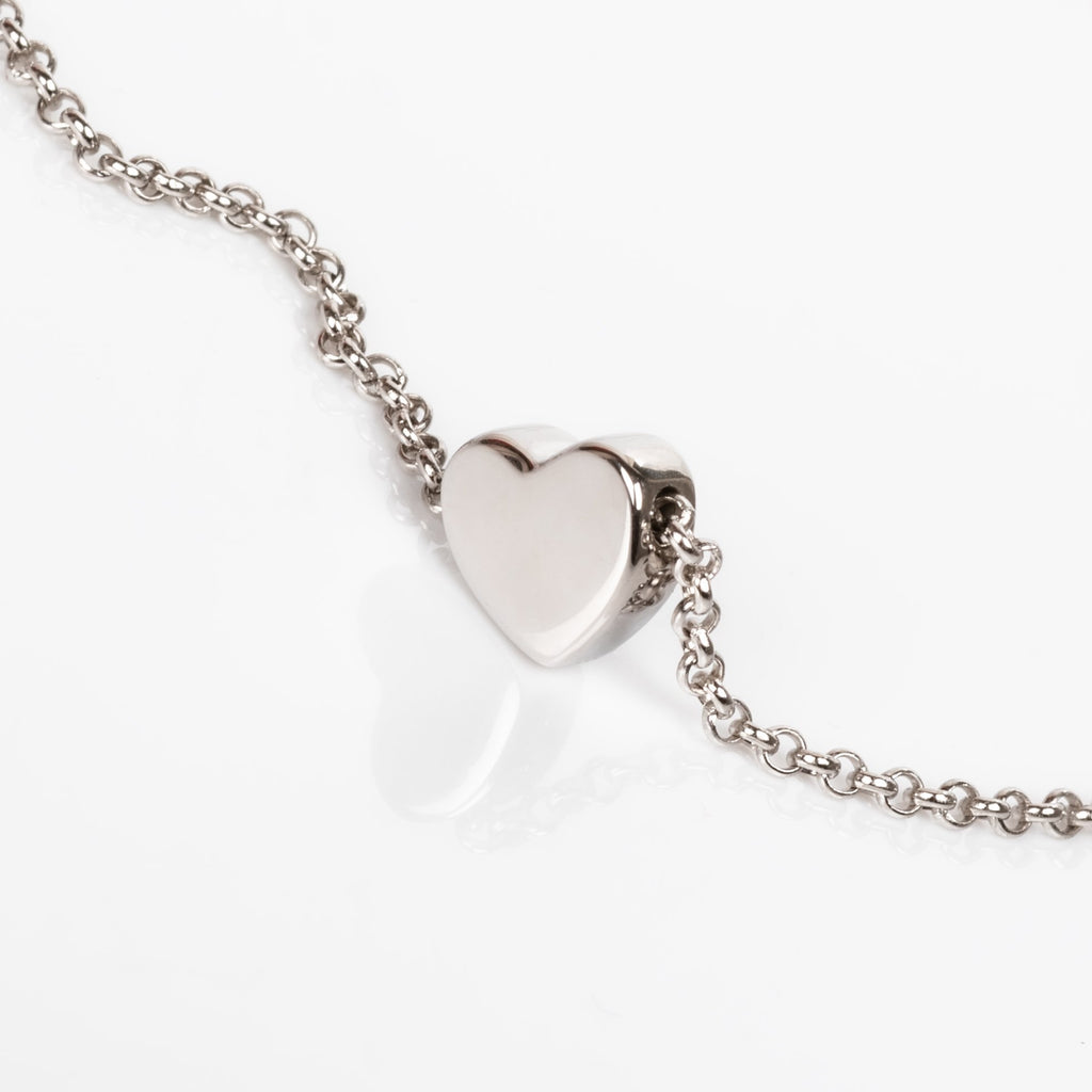 1. Close-up of MyaMoon Heart Choker in silver with a shiny bold heart on a rolo chain