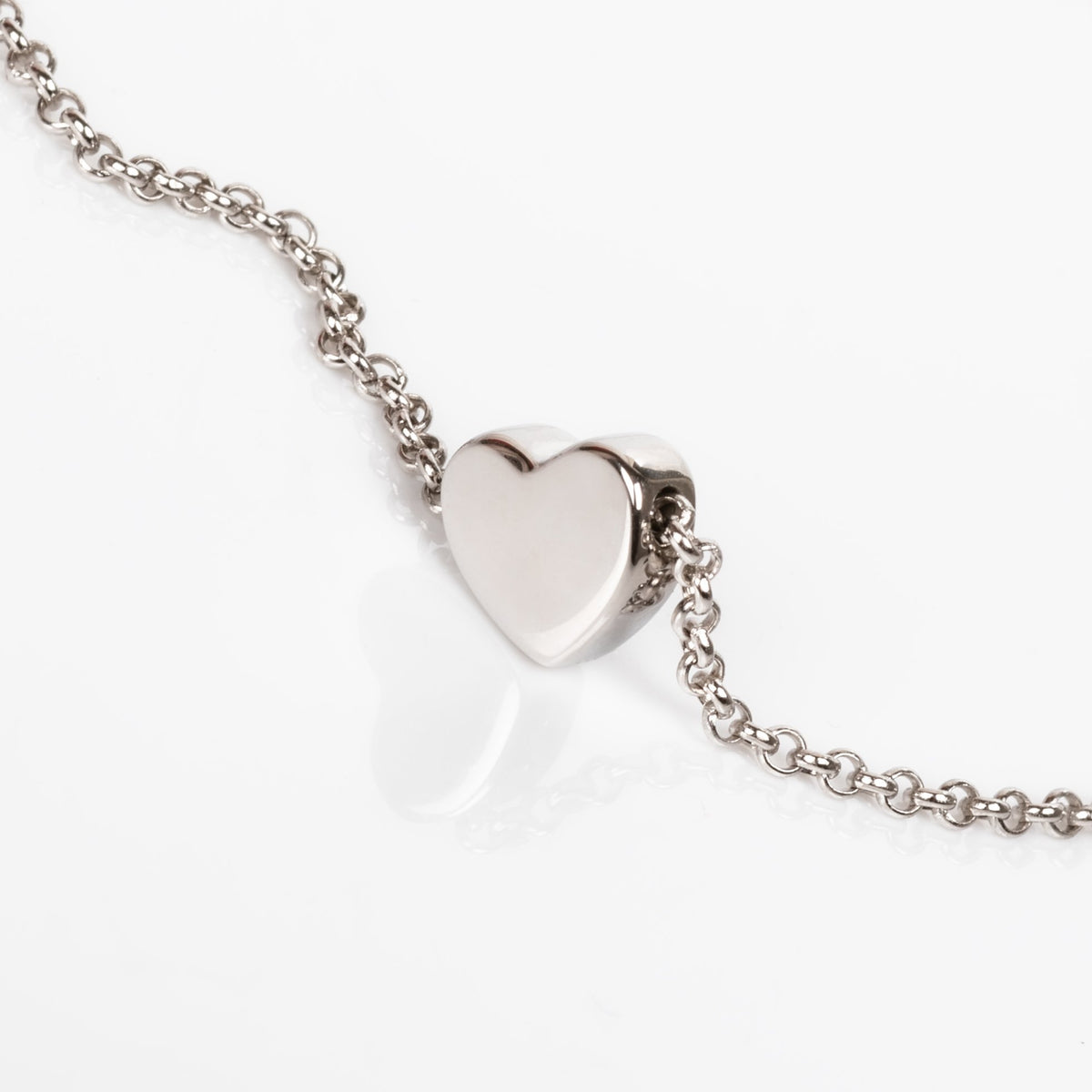 1. Close-up of MyaMoon Heart Choker in silver with a shiny bold heart on a rolo chain