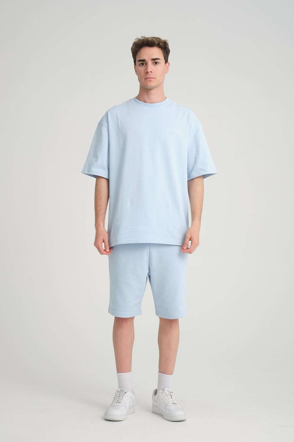 1. Man wearing baby blue oversized t-shirt and shorts, front view, in studio setting