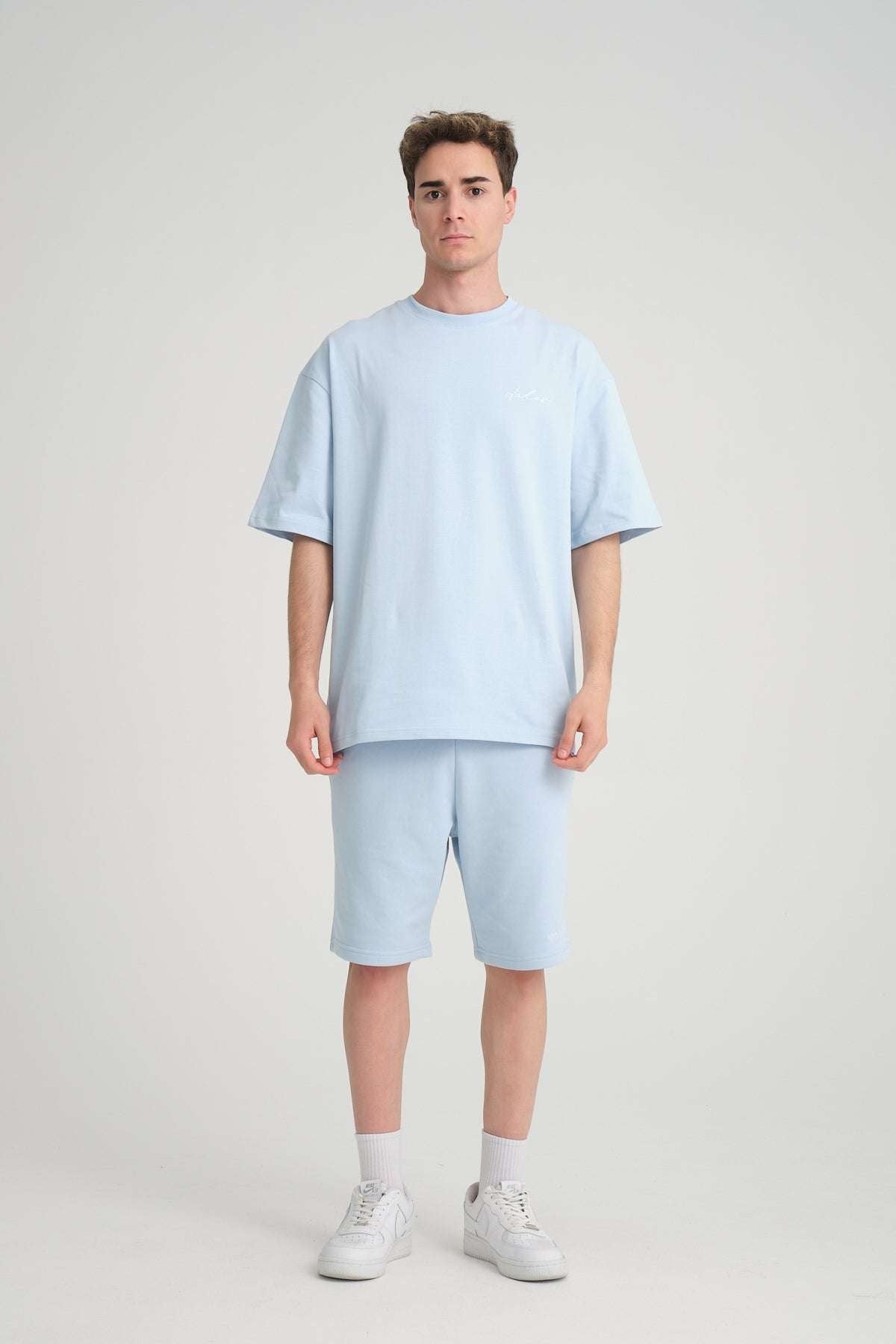 1. Man wearing baby blue oversized t-shirt and shorts, front view, in studio setting