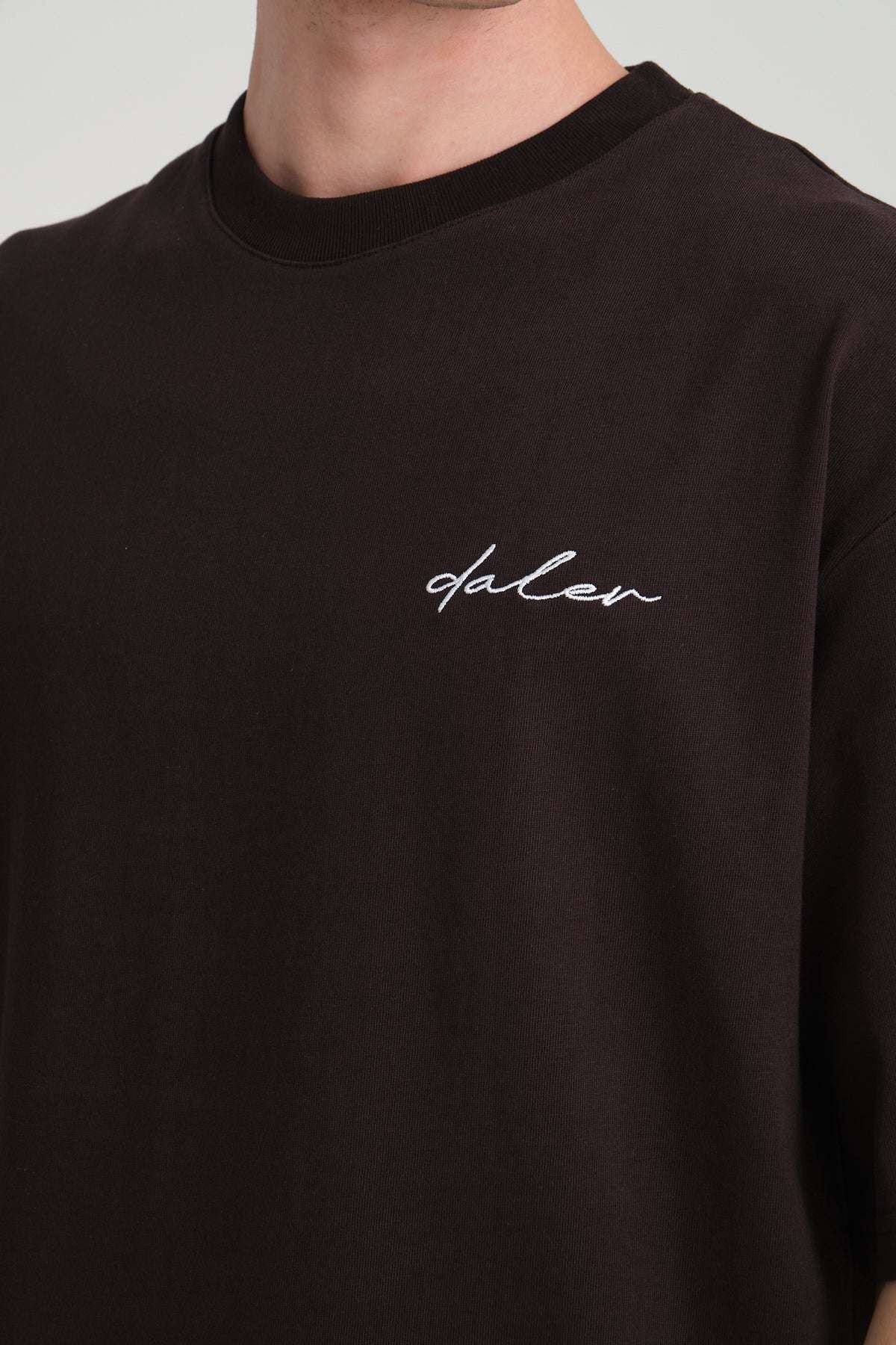 2. Close-up of black DalerClo t-shirt showing embroidered logo on chest
