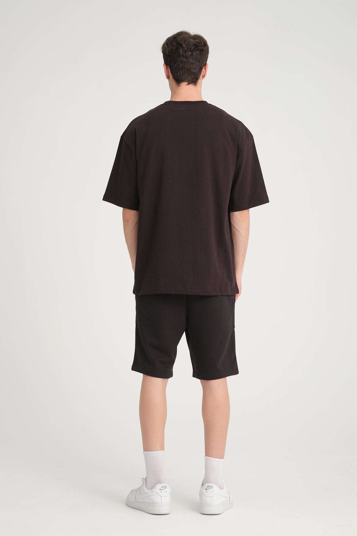 3. Back view of man wearing black oversized DalerClo t-shirt and shorts in studio
