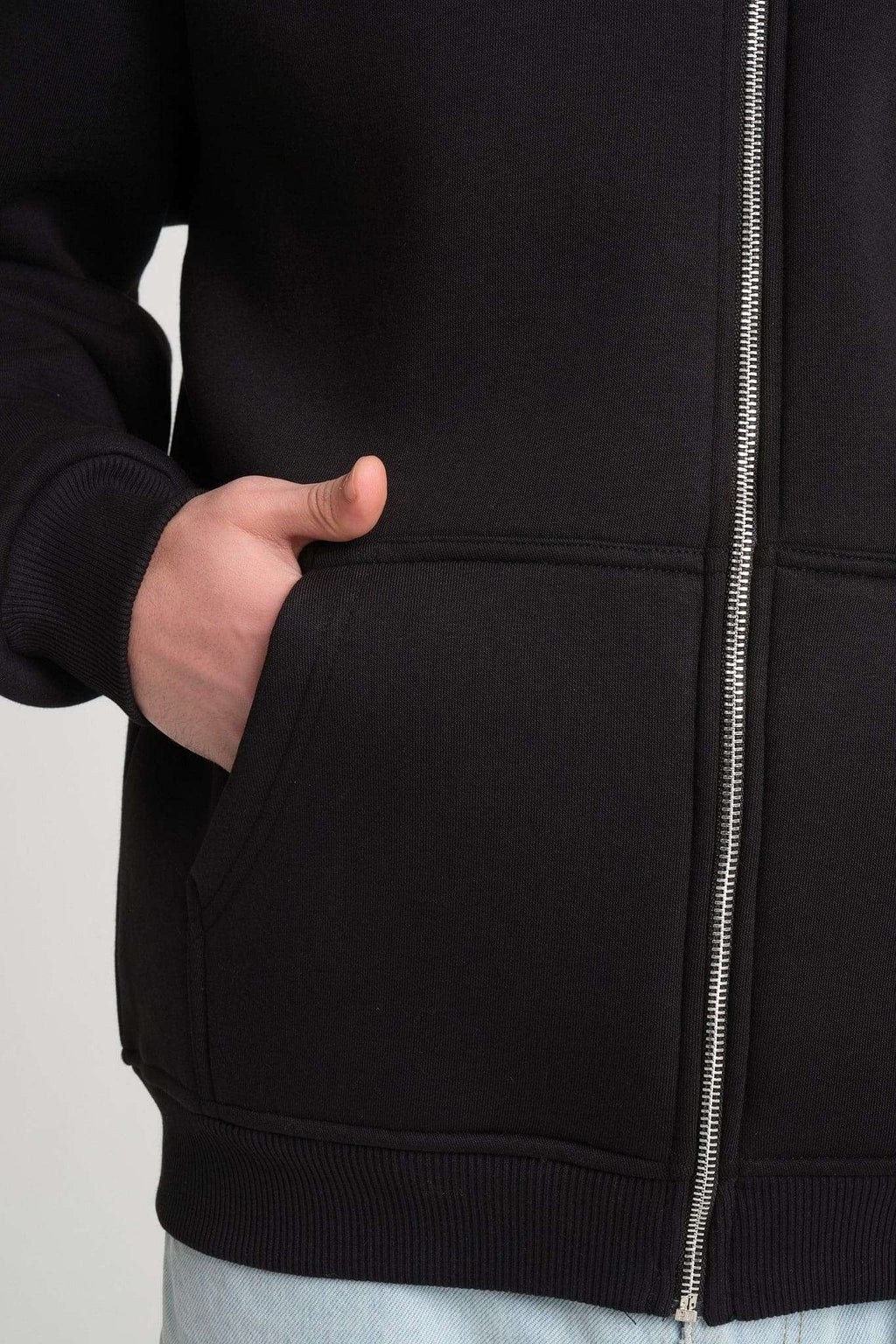6. Close-up of black hoodie pocket and zipper detail, highlighting the heavyweight fabric and craftsmanship.