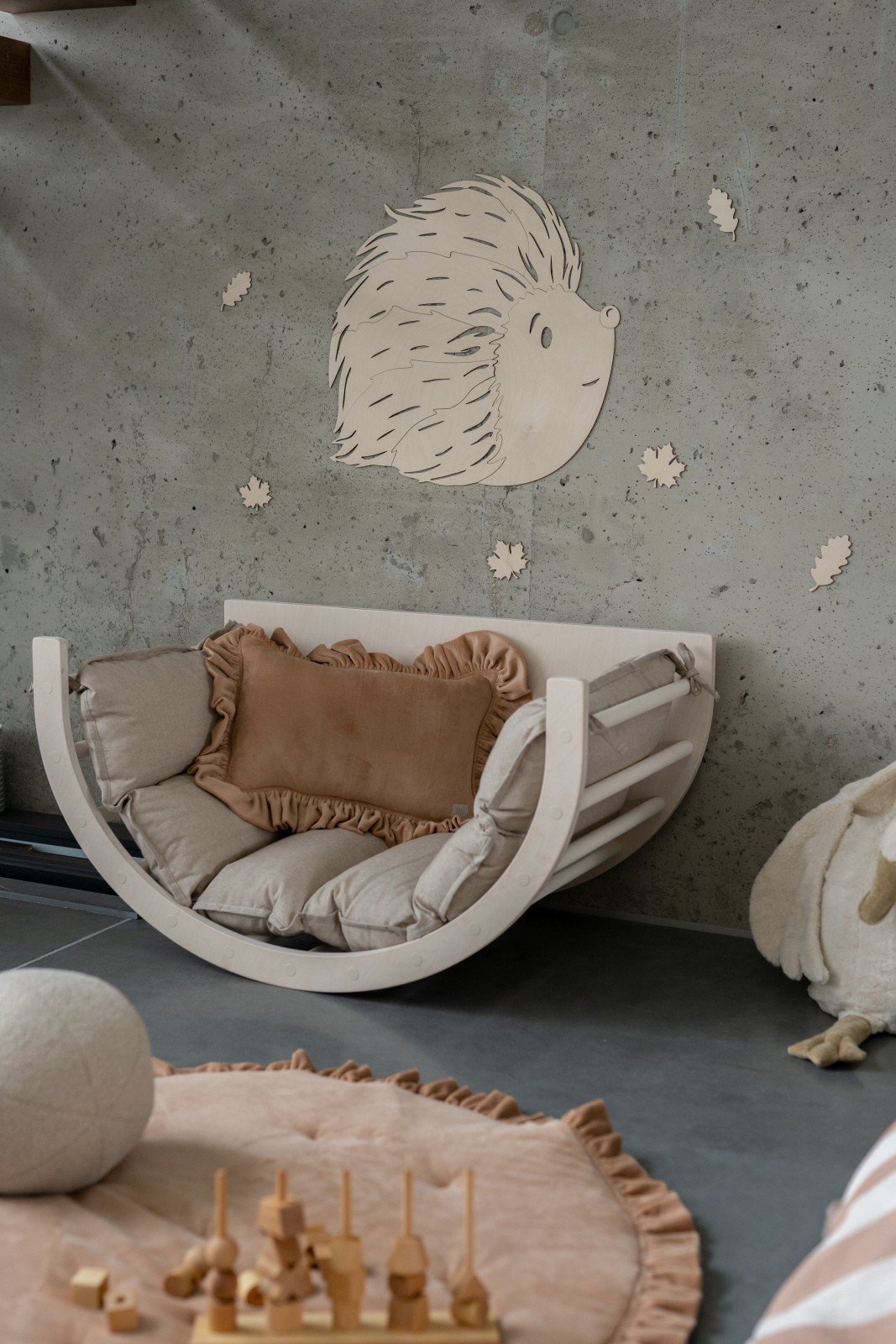 3. Birch plywood hedgehog wall decoration above cushioned seating in children's playroom