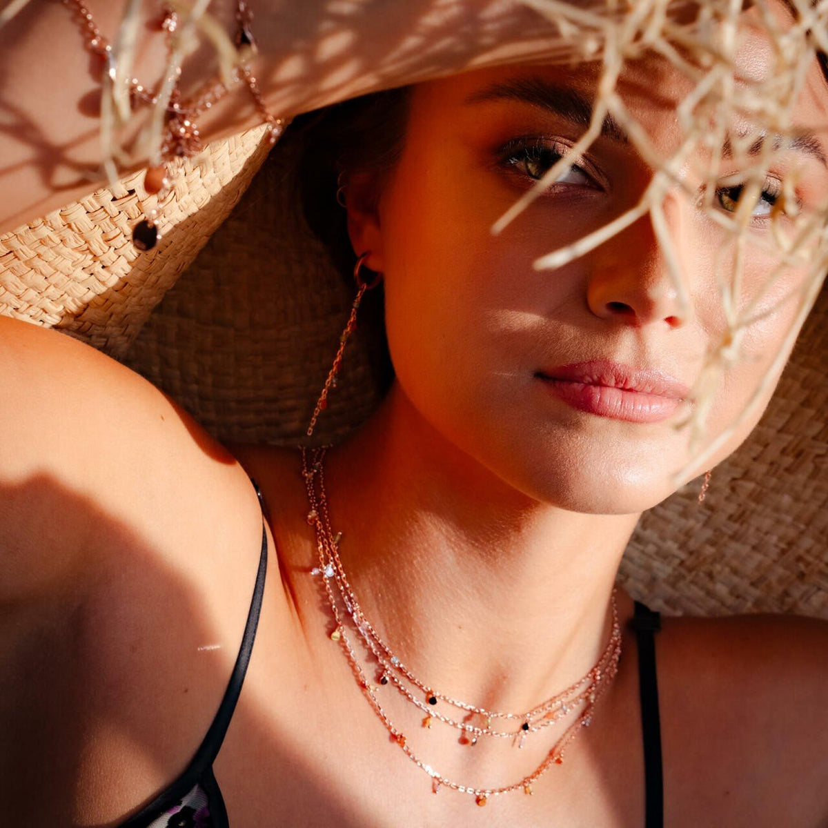1. Woman wearing MyaMoon Helena Choker in rose gold, adorned with pearls and beads, styled with a sun hat in a lifestyle setting
