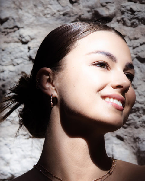 2. Close-up of woman wearing MyaMoon Aria Hoops M in rose gold, highlighting feminine elegance and Nordic design