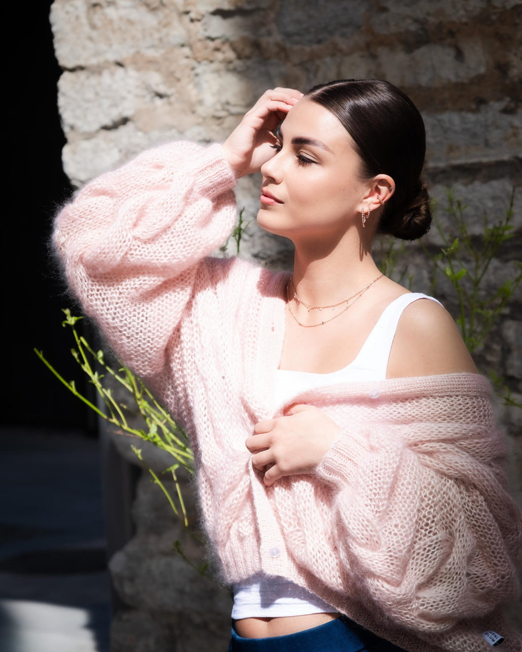 2. Woman in outdoor setting wearing MyaMoon Aria Hoops S in rose gold, paired with a pink cardigan, highlighting feminine elegance
