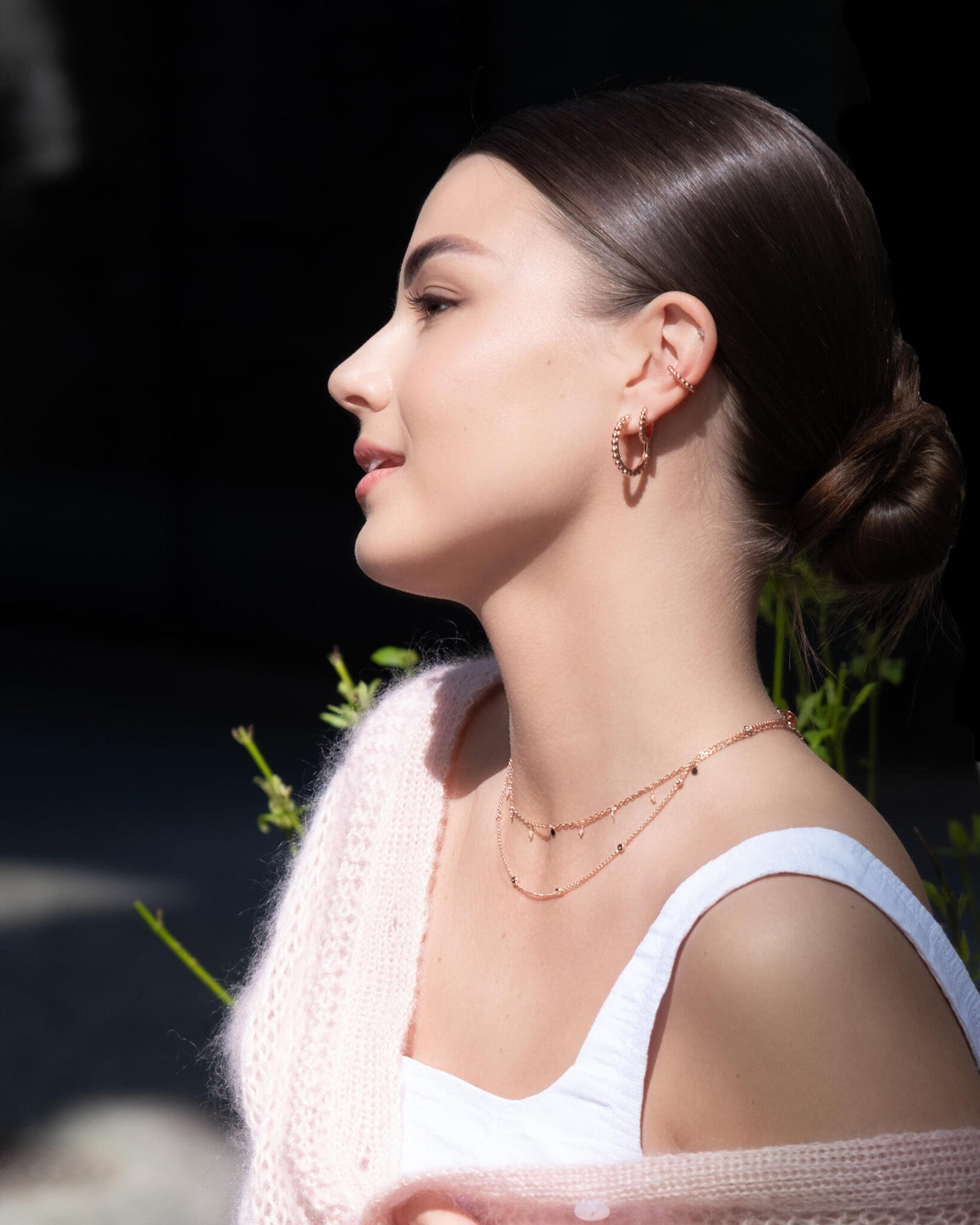 1. Woman wearing MyaMoon Aria Hoops S in rose gold, styled with a pink cardigan and white top, showcasing elegant Nordic minimalism