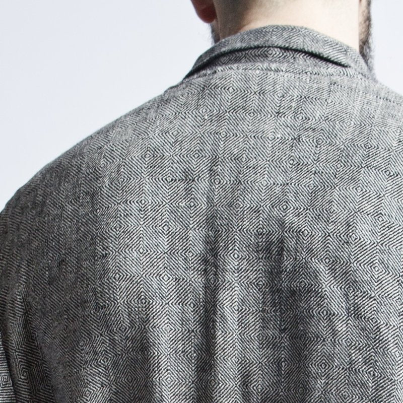 7. Close-up of back of grayish-black linen bathrobe with fishtail pattern, showing fabric texture