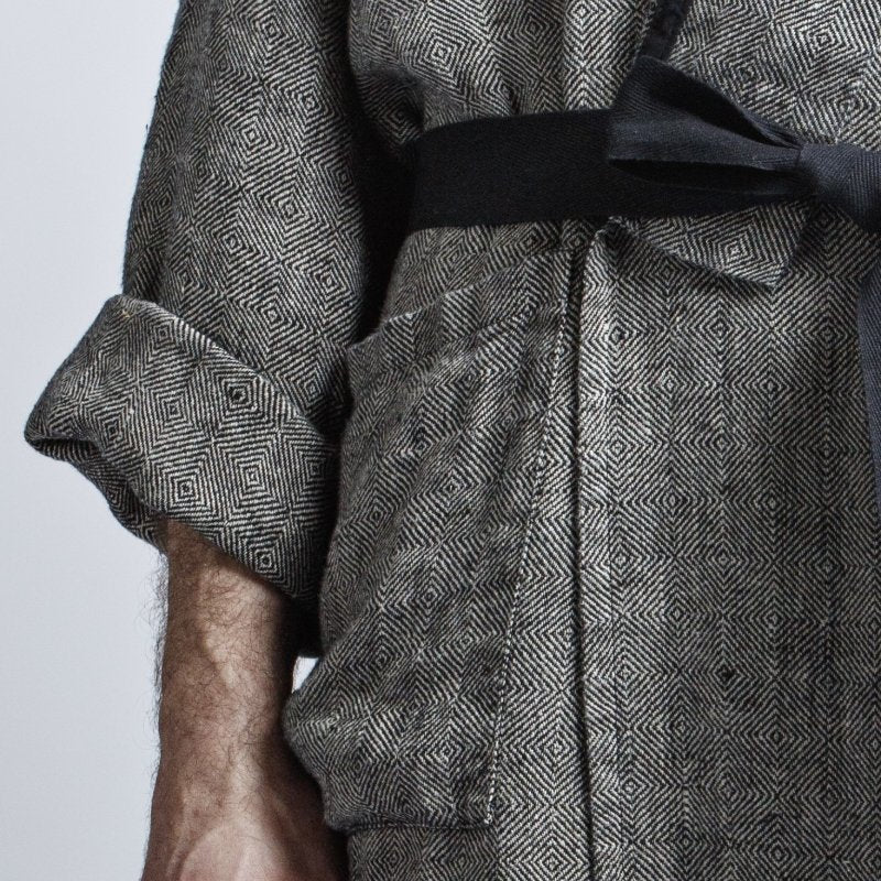 5. Close-up of grayish-black linen bathrobe with fishtail pattern, showing sleeve and black belt detail