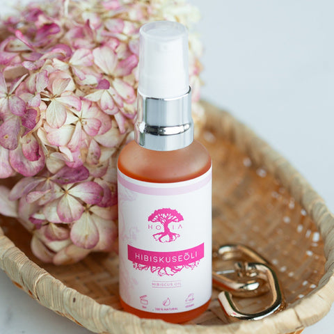 1. HOIA homespa Organic Hibiscus Beauty Oil, 50ml, displayed in a lifestyle setting with pink flowers