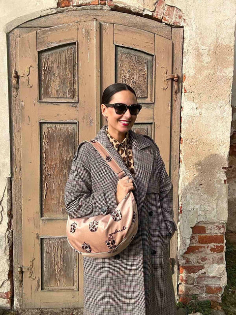 4. Woman wearing Garbanota Hobo Bag in Brown Leopard Tulips, styled with a coat, standing outdoors