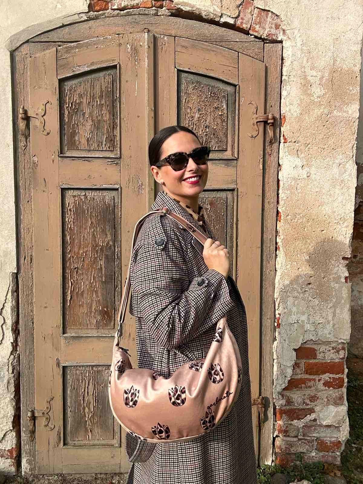 3. Woman wearing Garbanota Hobo Bag in Brown Leopard Tulips, styled with a coat, shown from the side outdoors