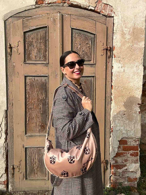 3. Woman wearing Garbanota Hobo Bag in Brown Leopard Tulips, styled with a coat, shown from the side outdoors