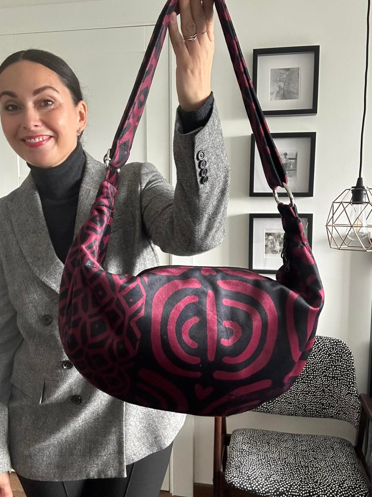 3. Woman holding Garbanota burgundy pattern hobo bag in indoor setting, highlighting adjustable strap and artistic design
