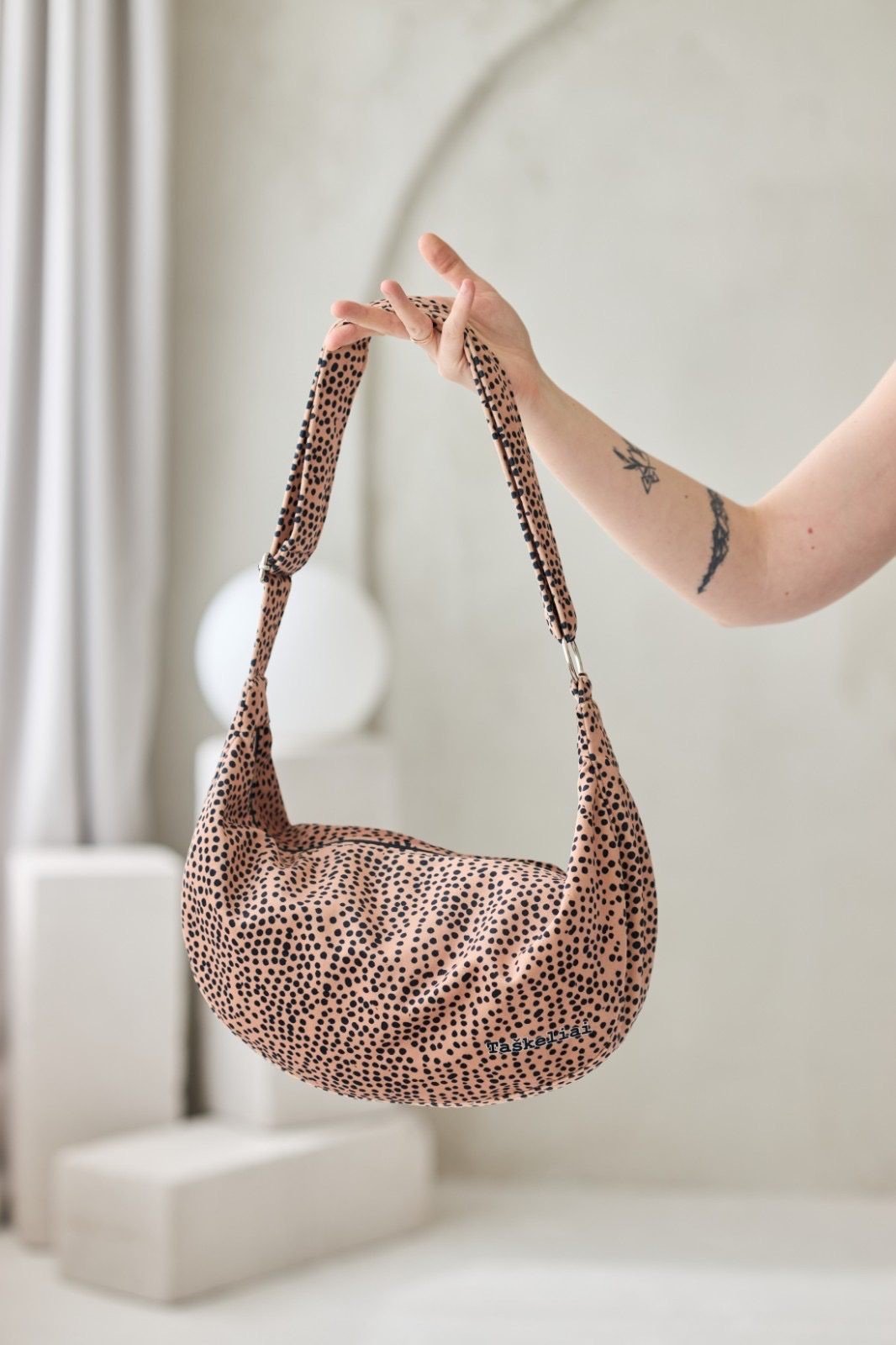 2. Garbanota cream and dots hobo bag with adjustable strap, shown in hand