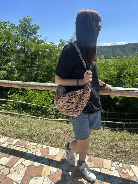 1. Woman outdoors wearing Garbanota cream and dots hobo bag with adjustable strap