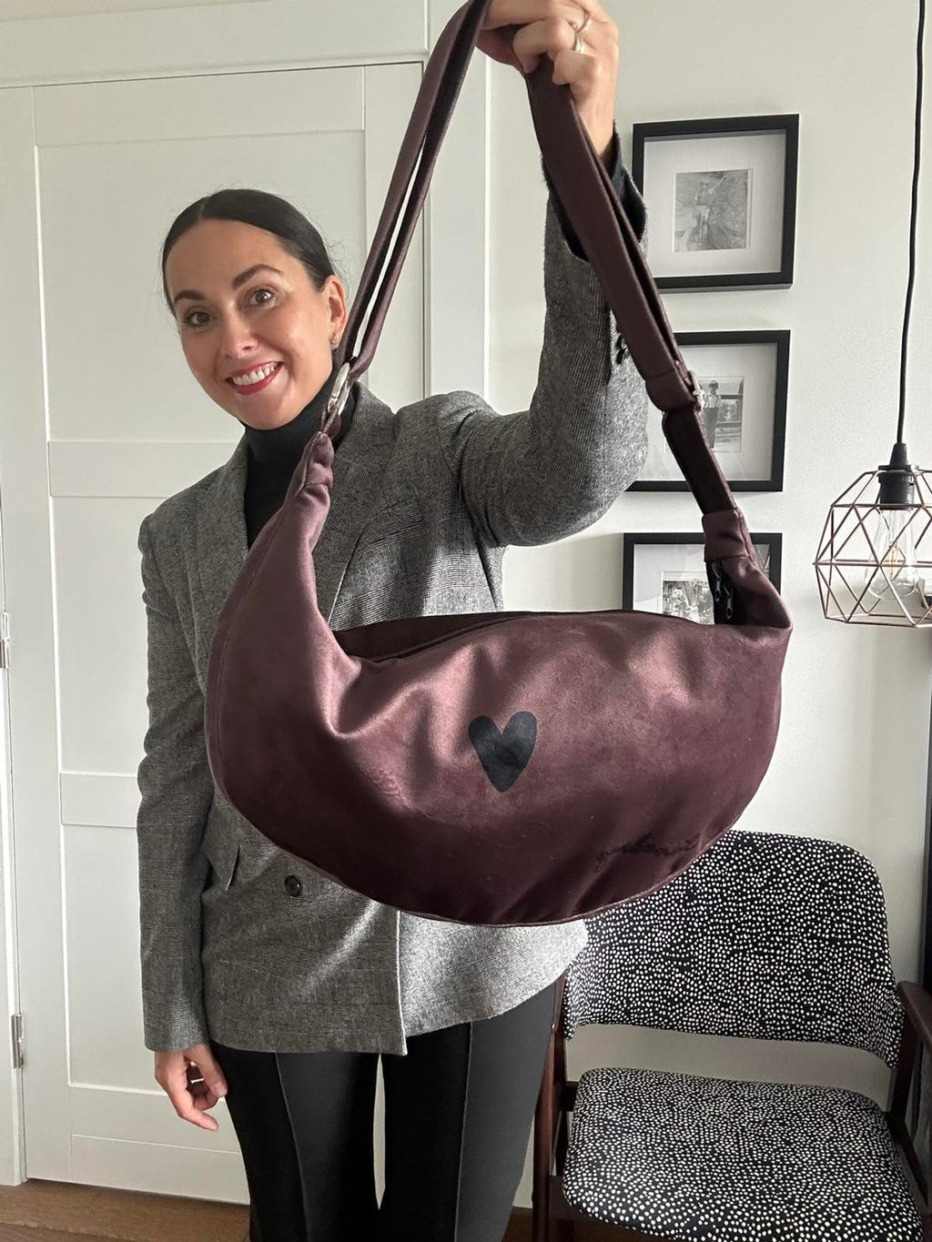 2. Woman holding Garbanota Hobo Bag Heart in brown velour, shown indoors with adjustable strap
