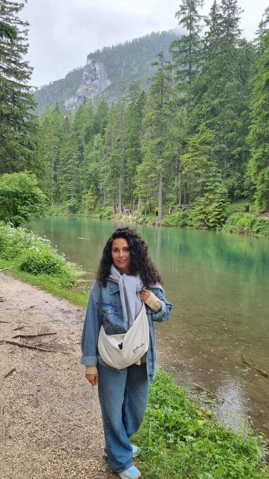 8. Woman walking by lake with Garbanota Hobo Bag Heart in white, wearing denim and casual attire
