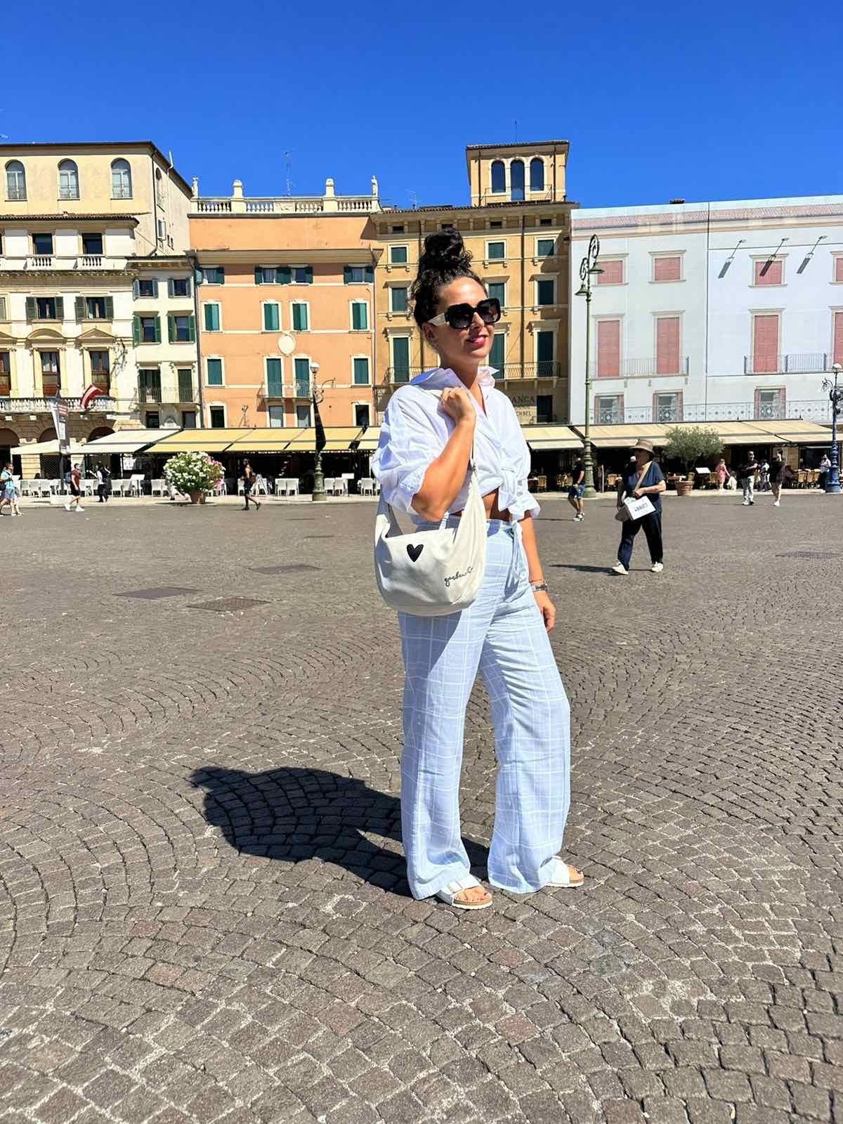 2. Woman in city square wearing Garbanota Hobo Bag Heart in white, styled with casual denim outfit