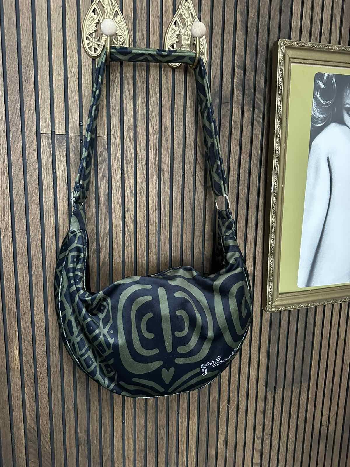 4. Garbanota Hobo Bag in khaki pattern on a wooden hook, showcasing the intricate pattern and brand logo