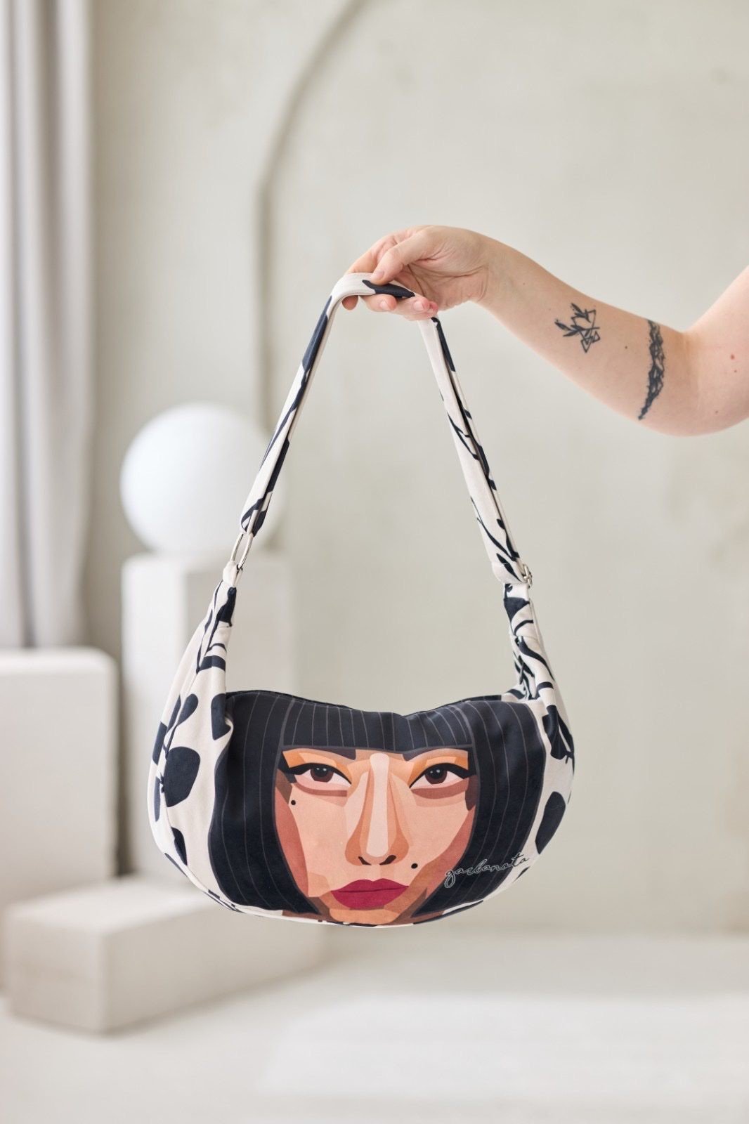 1. Garbanota KIYOKO Hobo Bag in black and white with artistic face design, held by a model in a lifestyle setting