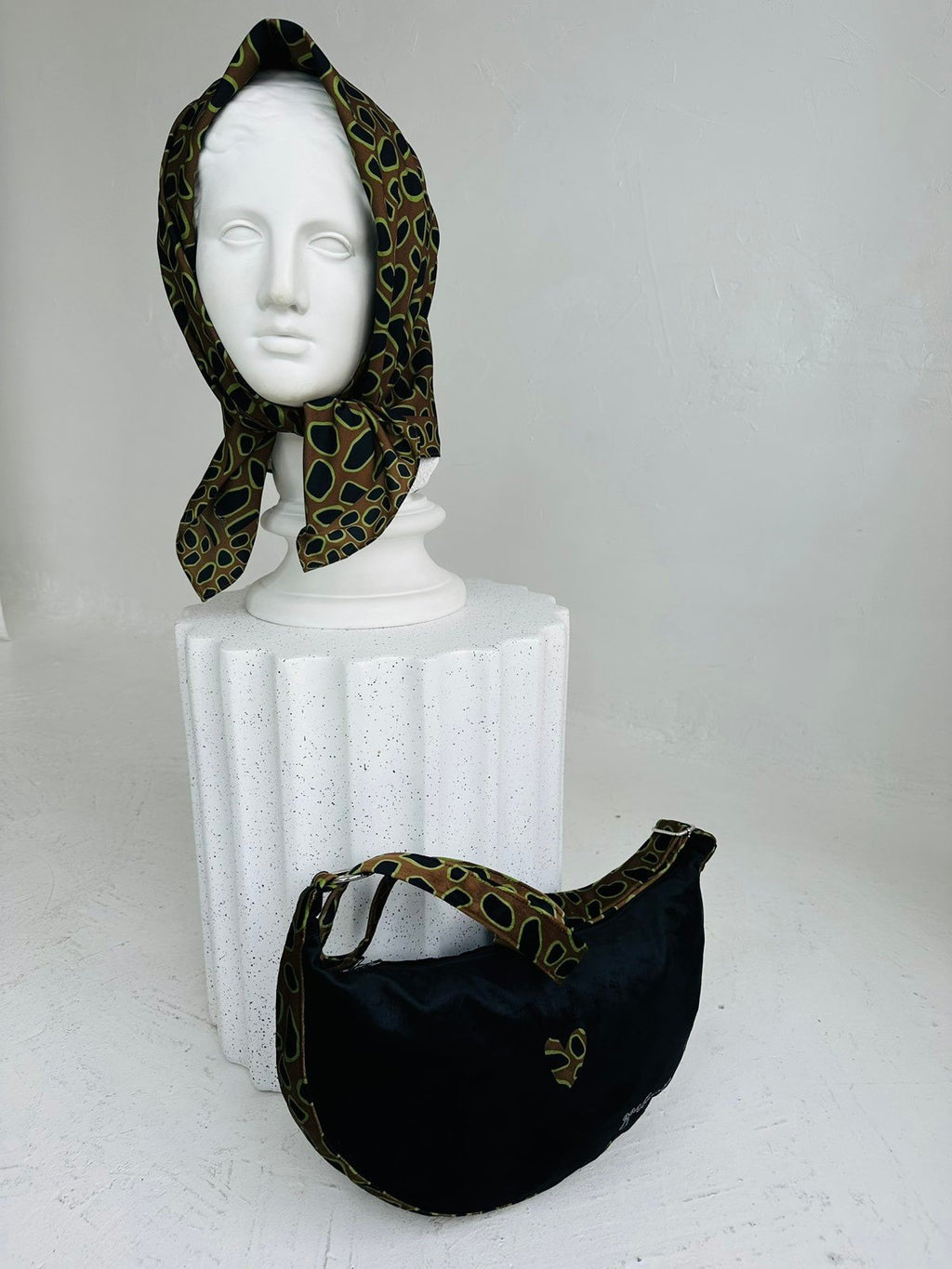 3. Side view of Garbanota Hobo Bag - Leopard Heart with matching scarf on mannequin, showing bag's shape