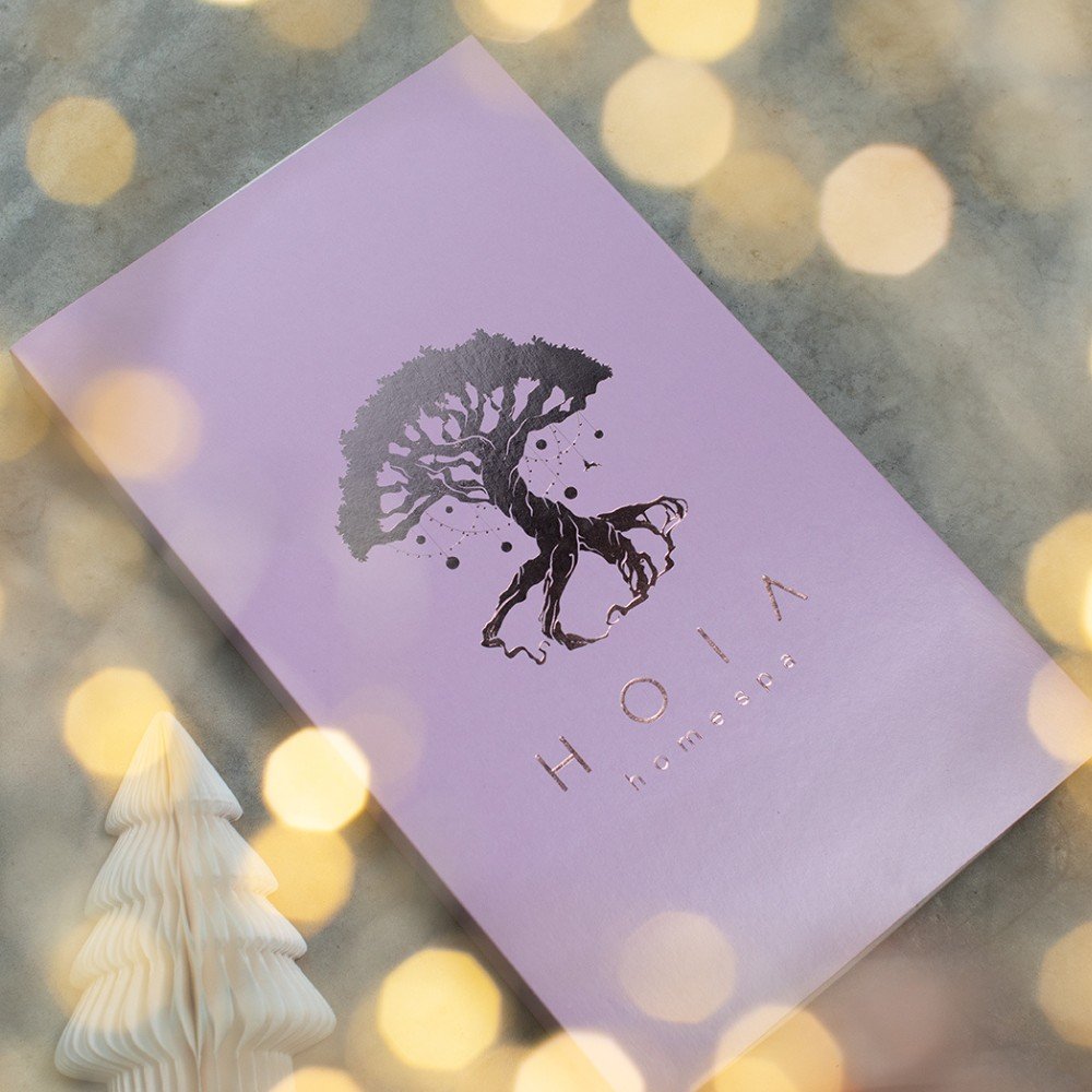 1. HOIA Advent Calendar 2025 in pink packaging with tree logo, surrounded by festive lights and a small decorative tree